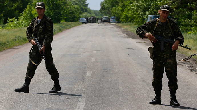 Ukrainian soldiers block traffic near the site (seen in background) where pro-Russian rebels killed thirteen Ukrainian servicemen on the outskirts of the eastern Ukrainian town of Volnovakha, south of Donetsk May 22, 2014.(Reuters / Yannis Behrakis )