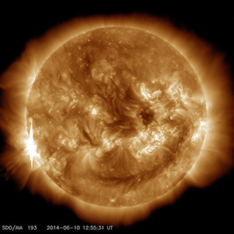 The second X-class flare of June 10, 2014, appears as a bright flash on the left side of this image from NASA’s Solar Dynamics Observatory. This image shows light in the 193-angstrom wavelength, which is typically colorized in yellow. It was captured at 8:55 a.m EDT, just after the flare peaked. (Image Credit: NASA / SDO)