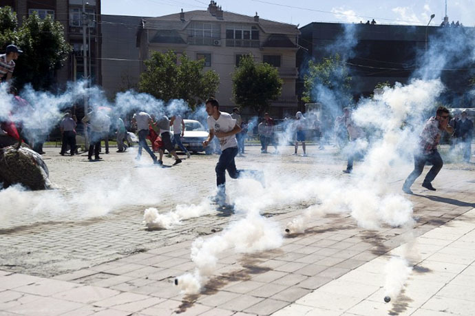 Οι Αλβανοί του Κοσσυφοπεδίου να τρέξει μακριά από βόμβες δακρυγόνων που τροφοδοτούνται από τα ΜΑΤ κατά τη διάρκεια συγκρούσεων στις 22 του Ιούνη του 2014 στη διχοτομημένη πόλη Μιτρόβιτσα. (AFP Φωτογραφία / Armend Nimani)