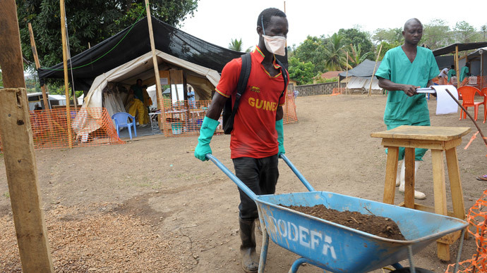 A worker transports durt in a wheelbarrow at a center for victims of the Ebola virus in Guekedou.(AFP Photo / Seyllou )