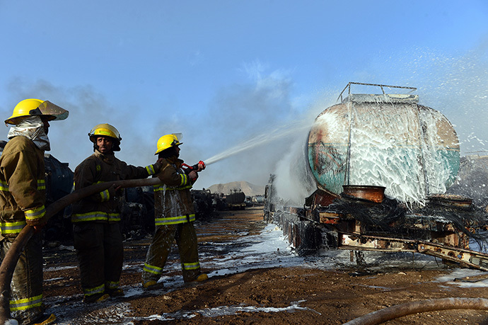Afghan firefighters attempt to extinguish burning fuel trucks following an overnight attack by Taliban militants in Chawk-e-Arghandi on outskirts of Kabul on July 5, 2014. (AFP Photo / Wakil Kohsar)