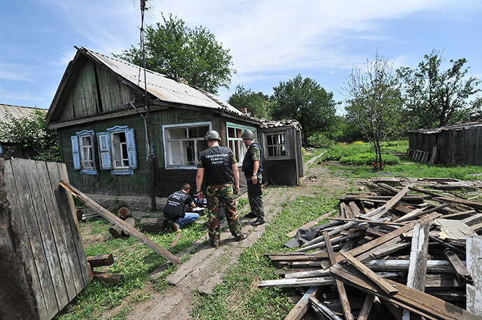 Os policiais trabalham na área, na cidade de Donetsk, na Região Rostov da Rússia, que foi atingido por um escudo de alto explosivo demitido do território ucraniano, 13 de julho de 2014. (RIA Novosti / Sergey Pivovarov)