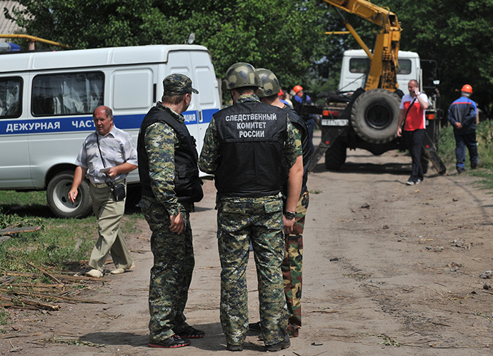 Os policiais trabalham na área, na cidade de Donetsk, na Região Rostov da Rússia, que foi atingido por um escudo de alto explosivo demitido do território ucraniano, 13 de julho de 2014. (RIA Novosti / Sergey Pivovarov)