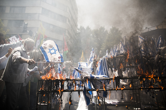 Iranian protestors burn Israeli flags during a demonstration in Tehran on July 25, 2014 to mark the Quds (Jerusalem) Day. (AFP Photo / Behrouz Mehri)