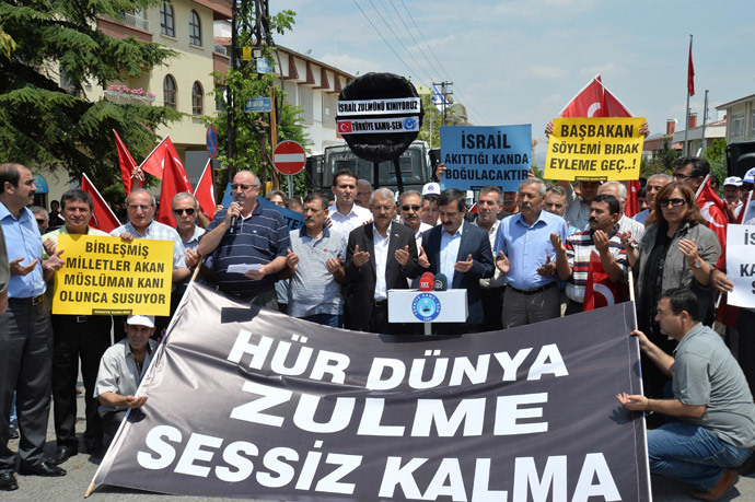 People take part in a demonstration outside the Israeli Embassy in the Turkish capital Ankara, on July 19, 2014, to protest against Israel's military campaign in Gaza and show their support to the Palestinian people. Banner reads : "The Free world remains silent to the cruelty". (AFP Photo / Adem Altan)