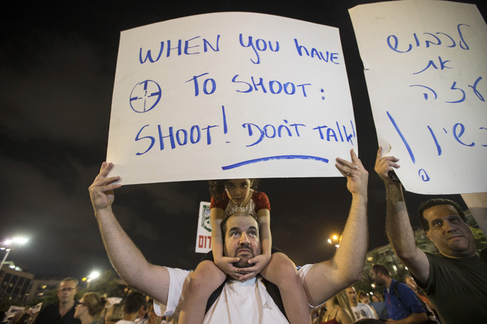 A man holds a sign during a rally in Tel Aviv's Rabin Square, to show solidarity with residents of Israel's southern communities, who have been targeted by Palestinian rockets and mortar salvoes, August 14, 2014. (Reuters / Baz Ratner)