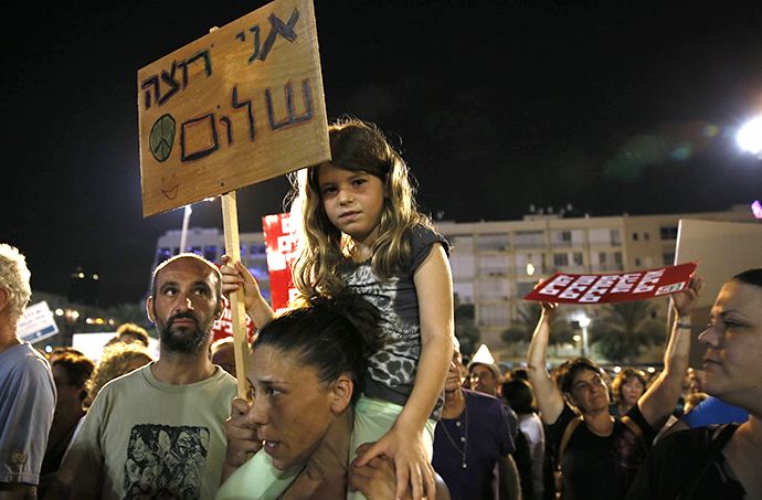 A young girl holds a placard reading in Hebrew: "I want peace" as thousands of Israelis protest during a left-wing peace rally in the coastal city of Tel Aviv calling for the Israeli government to negotiate with the Palestinian Authority on August 16, 2014. (AFP Photo / Gali Tibbon)