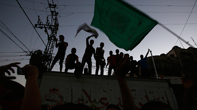 A Palestinian waves a Hamas flag (R) as others celebrate what they said was a victory over Israel, following a ceasefire in Gaza City August 26, 2014 (Reuters / Suhaib Salem)