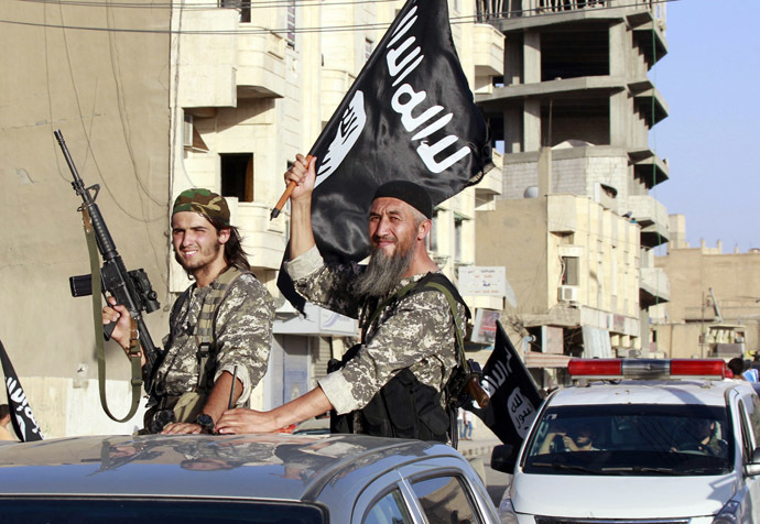 Combatentes islâmicos militantes acenam bandeiras como eles participar de um desfile militar pelas ruas da província do norte da Síria Raqqa 30 de junho de 2014 (Reuters)