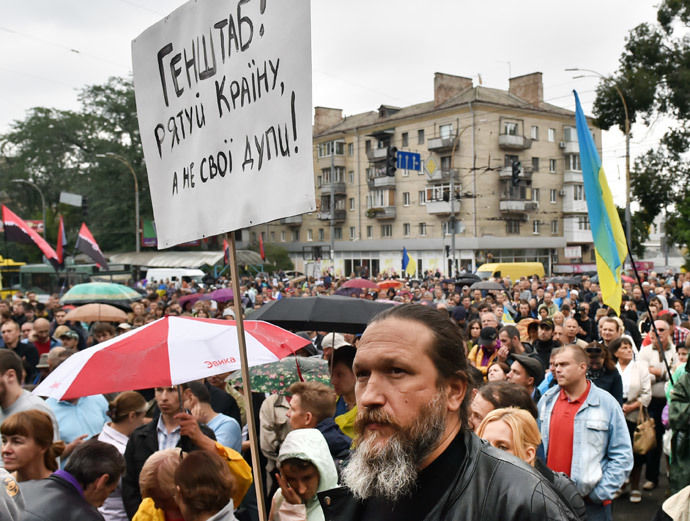 A man holds a placard " General Staff save Ukraine but not your asses!" during the rally in front of the Ukrainian Defence Ministery in Kiev on August 28, 2014.(AFP Photo / Sergei Supinsky)