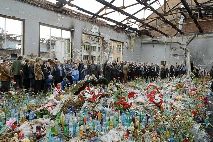Ossetians mourn at the destroyed school's gymnasium in Beslan 12 October 2004. (AFP Photo/Maxim Marmur)
