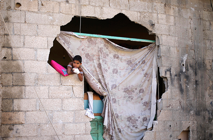 A Palestinian boy looks out of his damaged house after a ceasefire was declared, in the east of Khan Younis in the southern Gaza Strip August 27, 2014 (Reuters / Ibraheem Abu Mustafa)