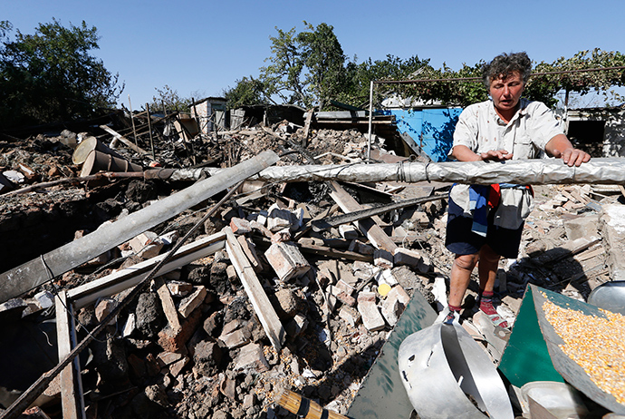 A woman stands at her destroyed house in the village of Kominternovo, on the outskirts of the southern coastal town of Mariupol, September 6, 2014 (Reuters / Vasily Fedosenko)