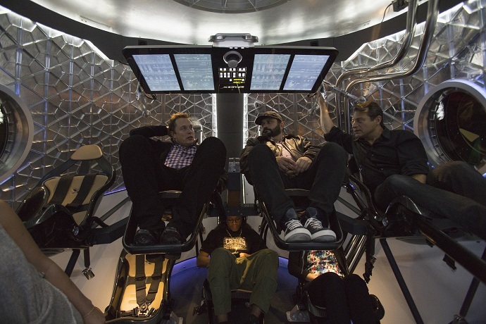 SpaceX CEO Elon Musk (L) sits with guests inside the Dragon V2 spacecraft (Reuters/Mario Anzuoni)