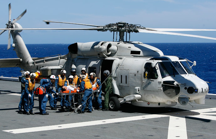 Members of the Japan Maritime Self-Defense Force (JMSDF) unload a patient from a UH 60 Seahawk in a Humanitarian Assistance and Disaster Relief drill aboard the JMSDF ship JS ISE, south of Oahu during the multi-national military exercise RIMPAC in Honolulu, Hawaii, July 12, 2014. (Reuters / Hugh Gentry)