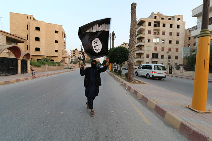 A member loyal to the Islamic State in Iraq and the Levant (ISIL) waves an ISIL flag in Raqqa June 29, 2014. (Reuters/Stringer)