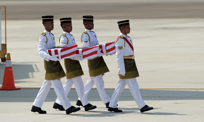 Soldiers carry coffins with the remains of Malaysian victims from the Malaysia Airlines flight MH17 that crashed in Ukraine during a ceremony at the Bunga Raya complex at Kuala Lumpur International Airport in Sepang on August 22, 2014. (AFP Photo)