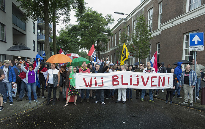 People hold a banner reading "We are here to stay" during a protest against the Islamic State (IS) group and against antisemitism in The Hague, The Netherlands, on August 10, 2014. (AFP Photo/Bart Maan/Netherlands out)