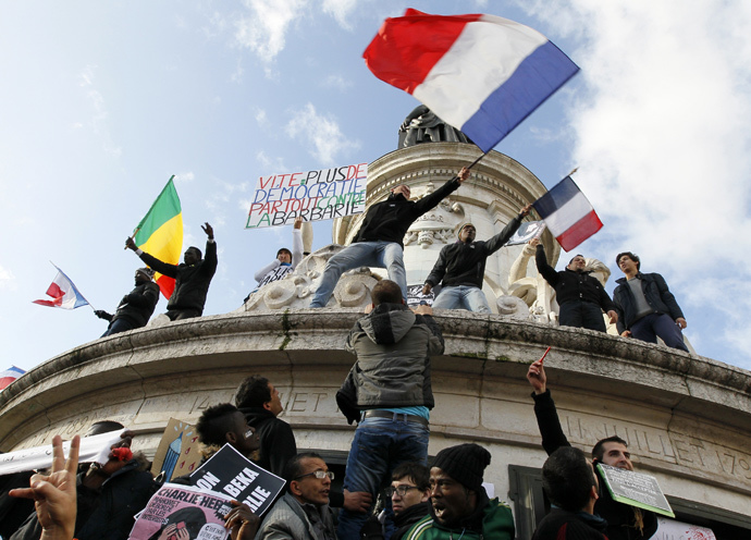 People holding a poster reading "Quick more democracy everywhere against barbarism" take part in a solidarity march (Marche Republicaine) in the streets of Paris January 11, 2015. (Reuters / Youssef Boudlal)
