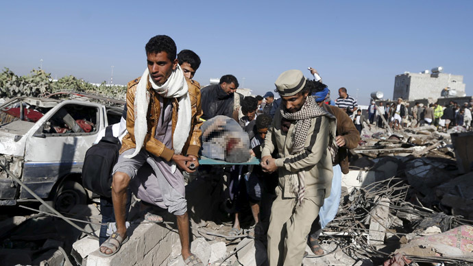 People carry the body of a man they uncovered from under the rubble of a house destroyed by an air strike near Sanaa Airport March 26, 2015. (Reuters / Khaled Abdullah)