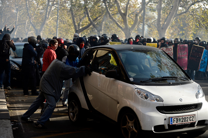 Demonstrators push a car during a protest on a day of mobilisation against austerity measures by workers in southern Europe on November 14, 2012 in Rome (AFP Photo / Filippo Monteforte)