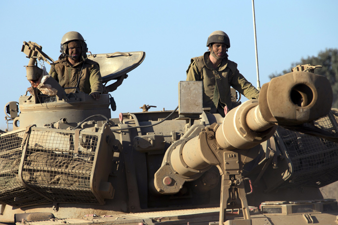Israeli soldiers ride on top of a mobile artillery vehicle as it drives through sandy terrain during a military exercise in the Israeli-occupied Golan Heights, north of Israel on Sepetember 19, 2012 (AFP Photo / Jack Guez)