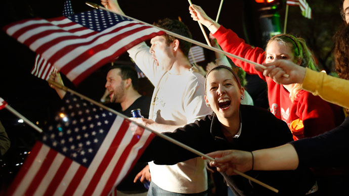 People wave U.S. flags while cheering as police drive down Arlington street in Watertown, Massachusetts April 19, 2013.(Reuters / Shannon Stapleton)