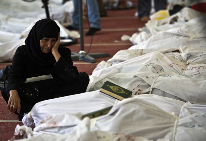 An Egyptian woman mourns over the body of her daughter wrapped in shrouds at a mosque in Cairo on August 15, 2013 (AFP Photo / Khaled Desouki)