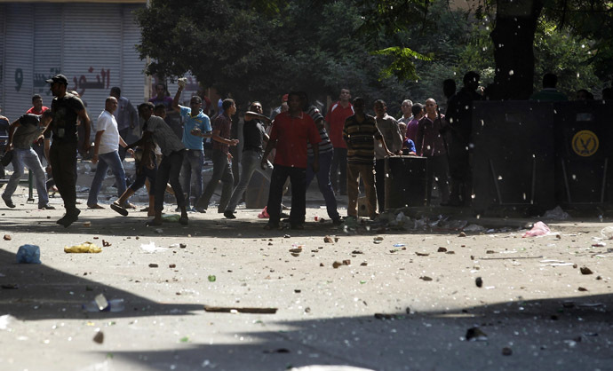 Police men and residents throw stones in front of Azbkya police station during clashes with protesters who support ousted Egyptian President Mohamed Mursi at Ramses Square in Cairo, August 16, 2013. (Reuters/Amr Abdallah Dalsh)