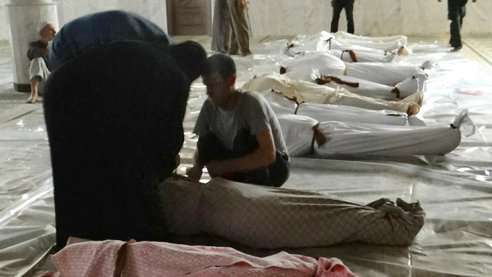 A handout image released by the Syrian opposition's Shaam News Network shows Syrians mourning in front of bodies wrapped in shrouds ahead of funerals following what Syrian rebels claim to be a toxic gas attack by pro-government forces in eastern Ghouta, on the outskirts of Damascus on August 21, 2013.  (AFP Photo/Shaam News Network)