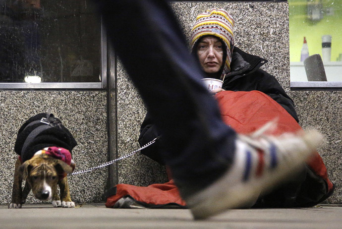 A homeless woman from north Wales, sits huddled under a sleeping bag next to her dog in a shopping arcade near the Victoria rail station in central London (Reuters/Chris Helgren)