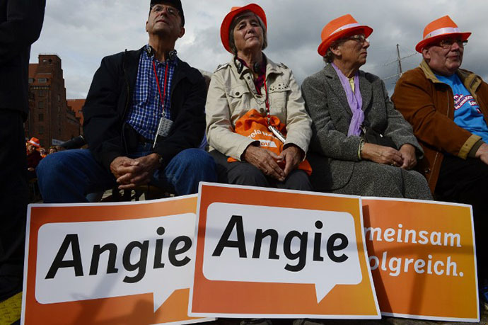 Supporters of German Chancellor Angela Merkel attend an election campaign event of the Christian Democratic Union (CDU) party on September 21, 2013 in Stralsund, eastern Germany, a day before the German general elections. (AFP Photo / John Macdougall)