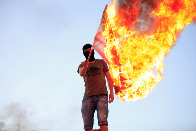 A protester burns a U.S. flag during a demonstration over the capture of senior al Qaeda figure Abu Anas al-Liby by U.S. authorities, in Benghazi October 11, 2013. (Reuters/Esam Omran Al-Fetori)