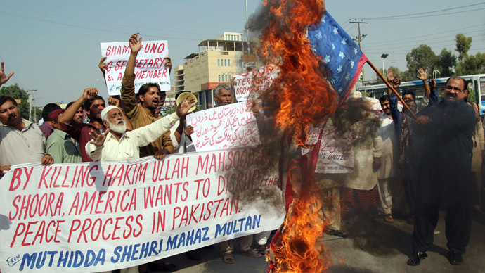 A Pakistani protester from United Citizen Action (UCA) holds a burning US flag as others shout anti-US slogans during a protest against the killing of Taliban leader Hakimullah Mehsud in a US drone attack in Pakistani tribal region, in Multan on November 2, 2013. (AFP Photo/S. S. Mirza)