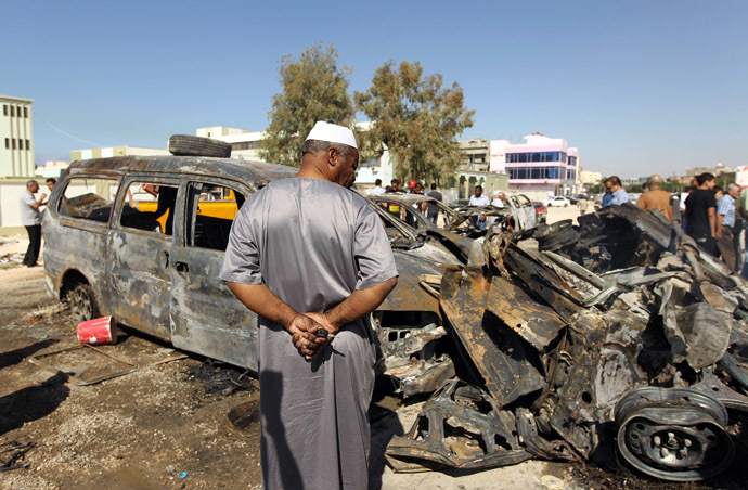 Benghazi residents gather at the site of a car blast in the parking lot of school used as an electoral office on October 26, 2013. (AFP Photo)