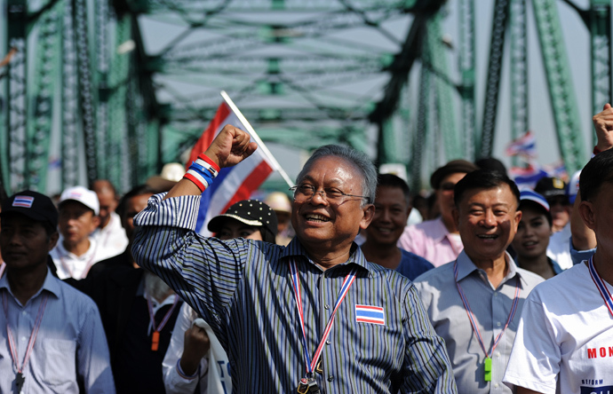 Thai protest leader Suthep Thaugsuban (C) clinches his fist as he leads a protest march through the streets of Bangkok on January 9, 2014 (AFP Photo / Christophe Archambault)