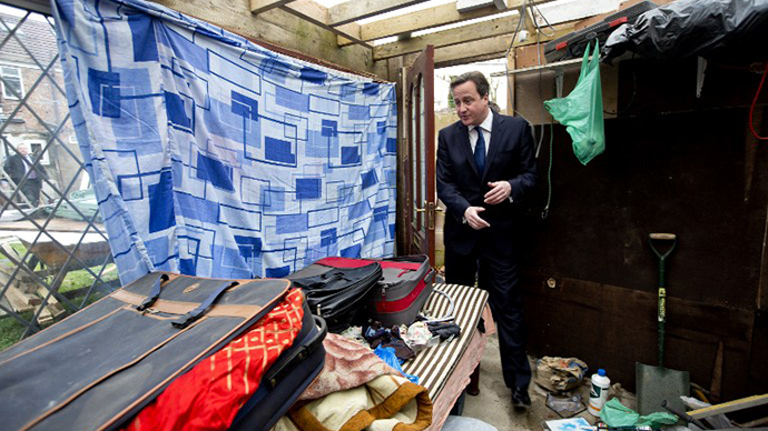 Britain's Prime Minister David Cameron is shown around a house in Southall in London on December 18, 2013 which was raided earlier in the day by immigration officers. (AFP Photo / David Bebber)