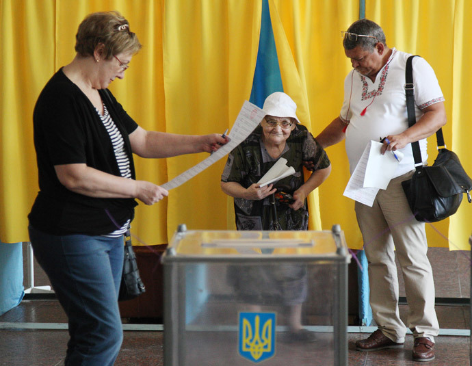 A man assists a woman with the casting of her ballot at polling station in the southern Ukrainian city of Dnipropetrovsk on May 25, 2014. (AFP Photo / Anatolii Stepanov)