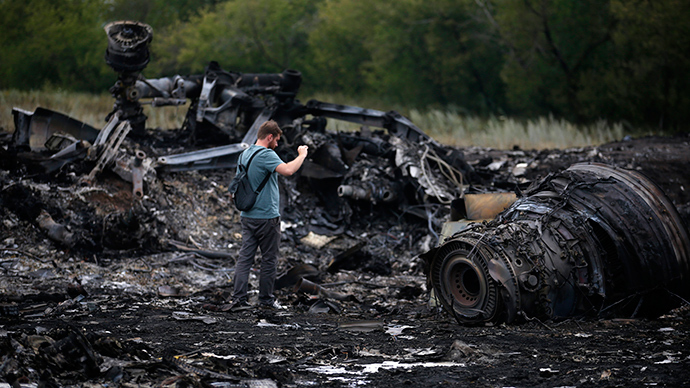 Um jornalista tira fotografias no local da Malaysia Airlines Boeing 777 acidente de avião na quinta-feira perto do assentamento de Grabovo, na região de Donetsk 18 de julho, 2014 (Reuters / Maxim Zmeyev)