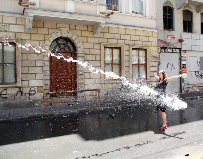A woman opens her arms as police use a water cannon to disperse protestors on June 1, 2013 during a protest against the demolition of Taksim Gezi Park in Istanbul (AFP Photo)