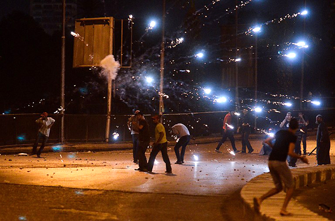 Ousted president Mohammed Morsi supporters and anti Morsi protesters hurl stones at each other as they clash near Egypt's landmark Tahrir square on July 5, 2013 in Cairo. (AFP Photo / Mohamed El-Shahed)