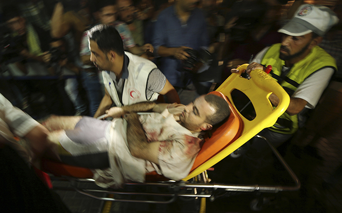 A wounded Palestinian, who hospital officials said was injured in an Israeli air strike, is wheeled into a hospital in Gaza City July 12, 2014. (Reuters / Mohammed Salem)