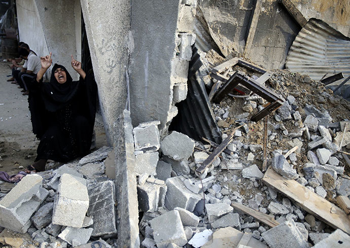 A Palestinian woman reacts next to the rubble of her relatives' house, which police said was destroyed in an Israeli air strike, in the southern Gaza Strip July 21, 2014. (Reuters / Ibraheem Abu Mustafa)
