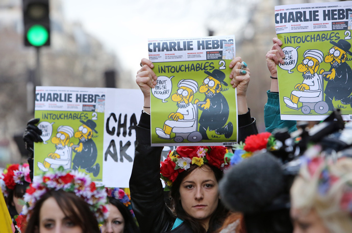 Femen activists hold Charlie Hebdo frontpages during a Unity rally “Marche Republicaine” on January 11, 2015 at the Place de la Republique (Republique's square) in Paris in tribute to the 17 victims of a three-day killing spree by homegrown Islamists. (AFP Photo / Loic Venance)