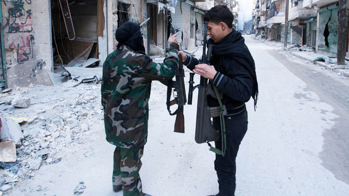 A female fighter in the Free Syrian Army exchanges her weapon with a fellow fighter in Aleppo's Salaheddine neighbourhood November 6, 2013. (Reuters / Mahmoud Hassano)
